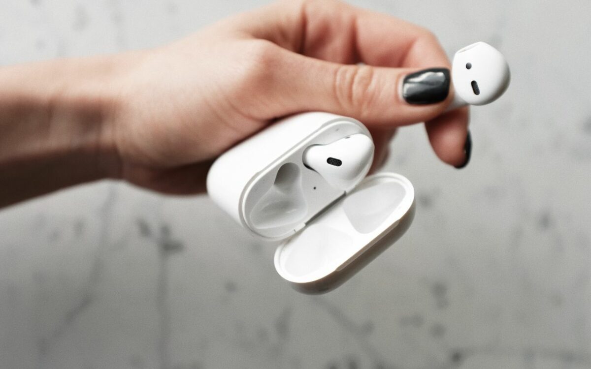 person holding airpods white